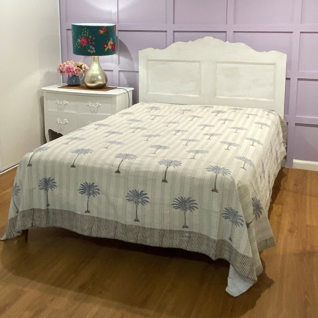 Blue palm bedspread on bed